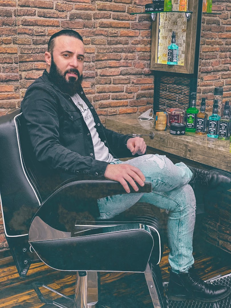 Barbier von KING Barbershop vor Backsteinwand